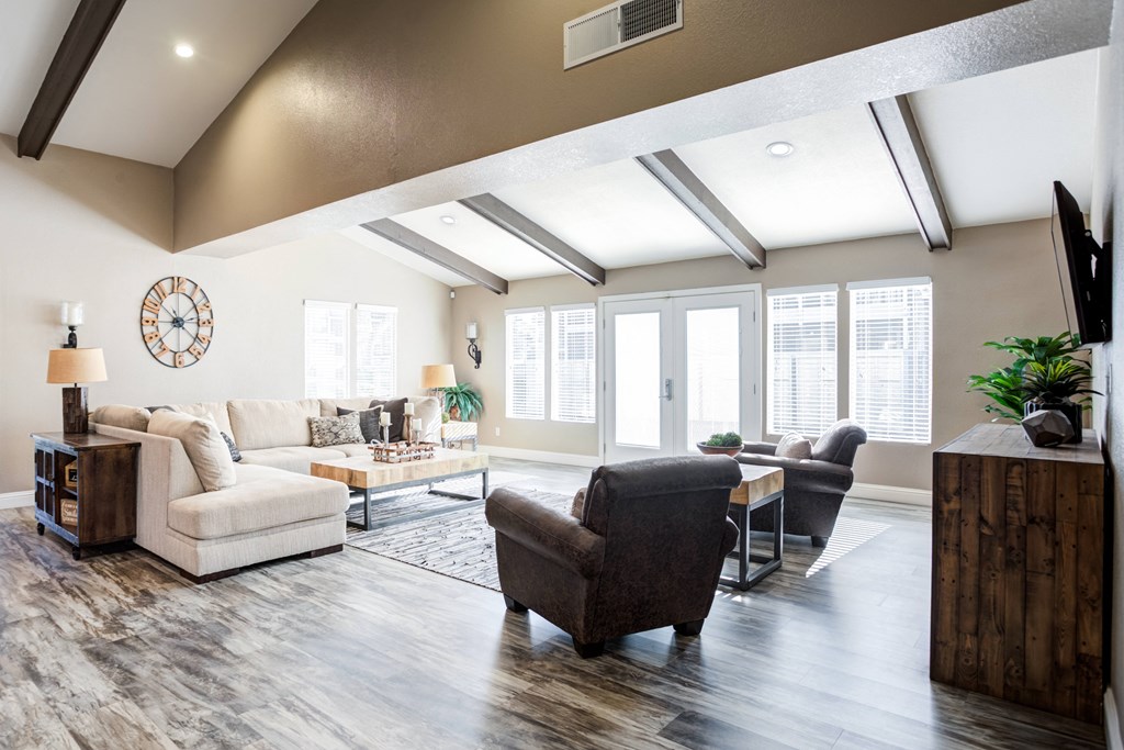 A living room with a white sofa, a brown armchair, and a wooden side table.