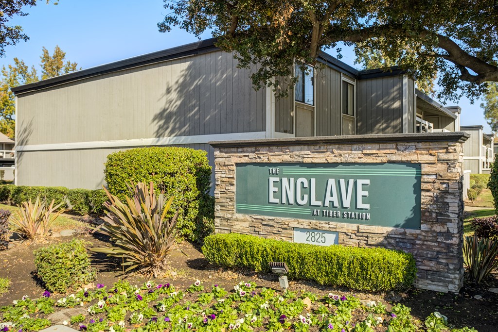 A sign that says "The Enclave at Tiburon Station" in front of a building.