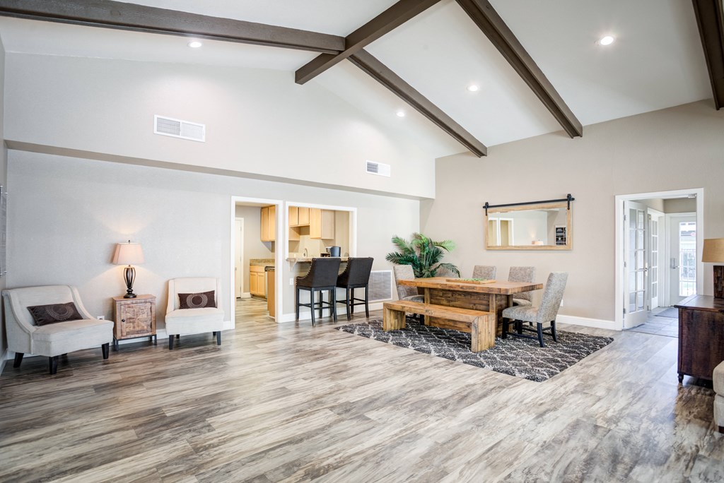 A spacious living room with a wooden floor and a high ceiling.