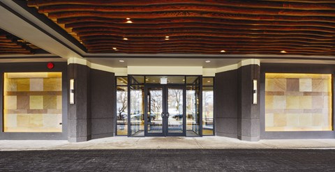 The image shows a building entrance with a red ceiling and glass doors.