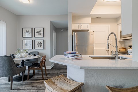a kitchen and dining room with a sink and a refrigerator