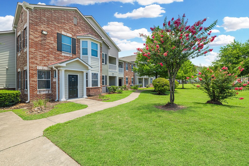 an apartment building with a sidewalk in front of it
