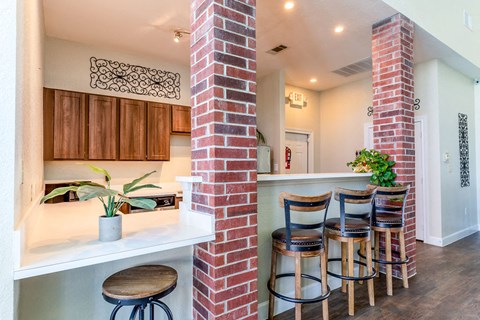 a kitchen with a counter and three bar stools