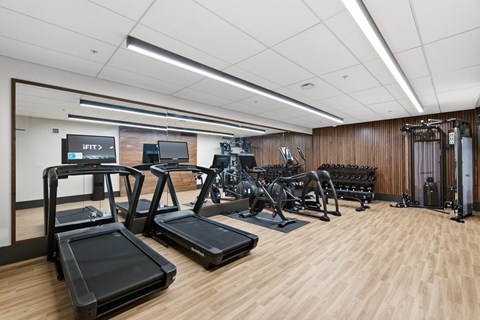 A gym with treadmills, elliptical machines, and other exercise equipment.