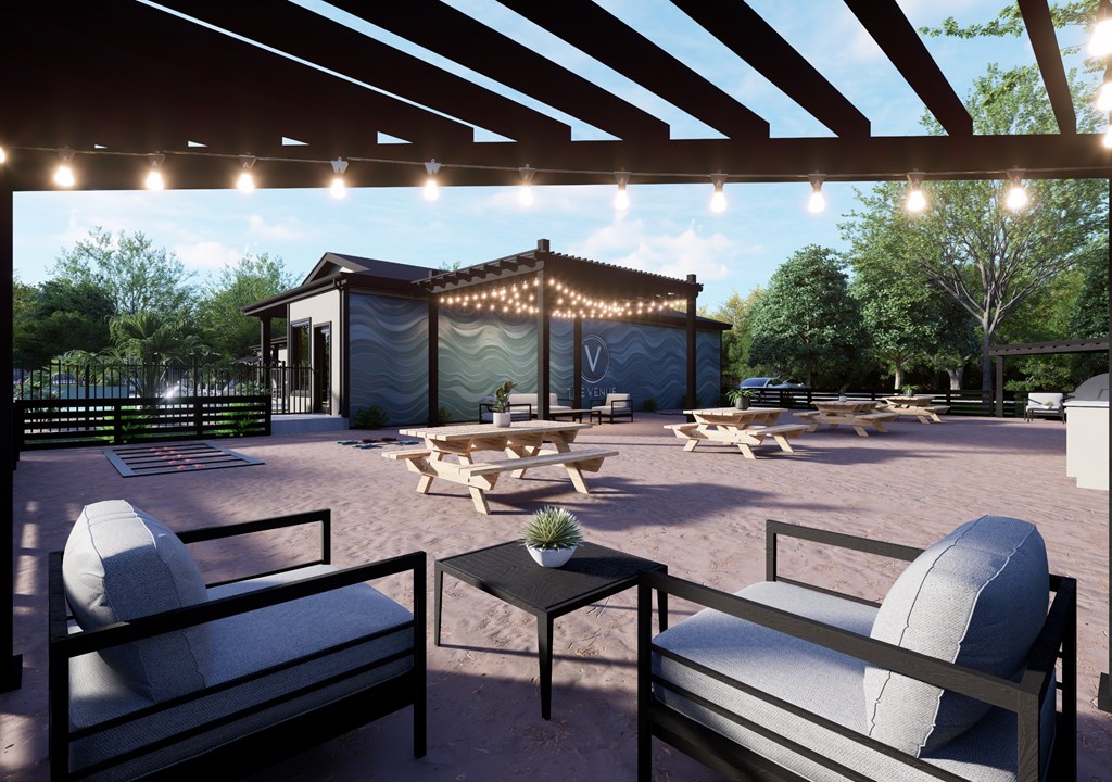 A patio with a table, chairs and a string of lights.