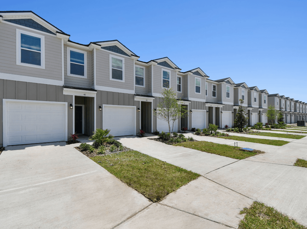 a row of town homes with garages and sidewalks