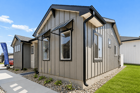 A modern house with a grey exterior and a black roof.