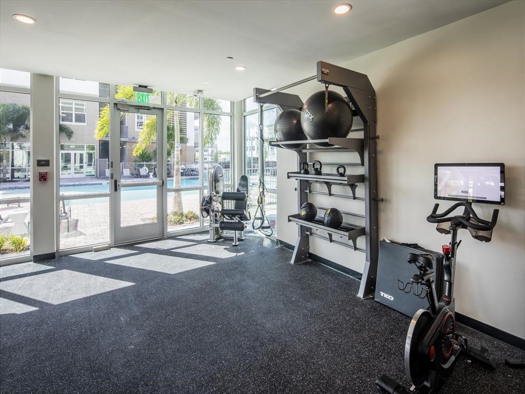 a workout room with a bike and a tv
