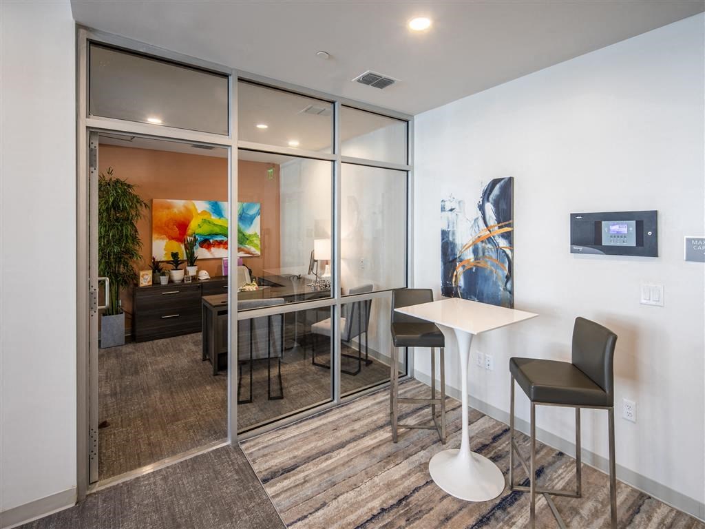 a dining room with a table and chairs in front of a mirrored wall