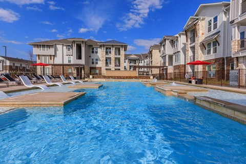 A swimming pool in front of apartment buildings.