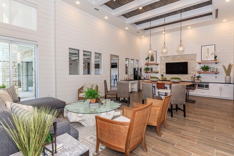 A modern living room with a glass table and wooden chairs.