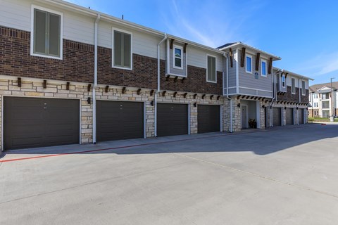 A row of houses with garages in front.