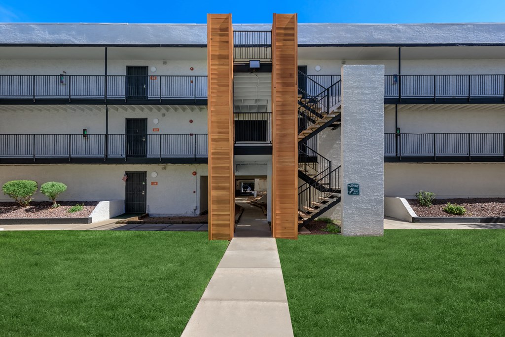 an exterior view of a building with a lawn and a staircase