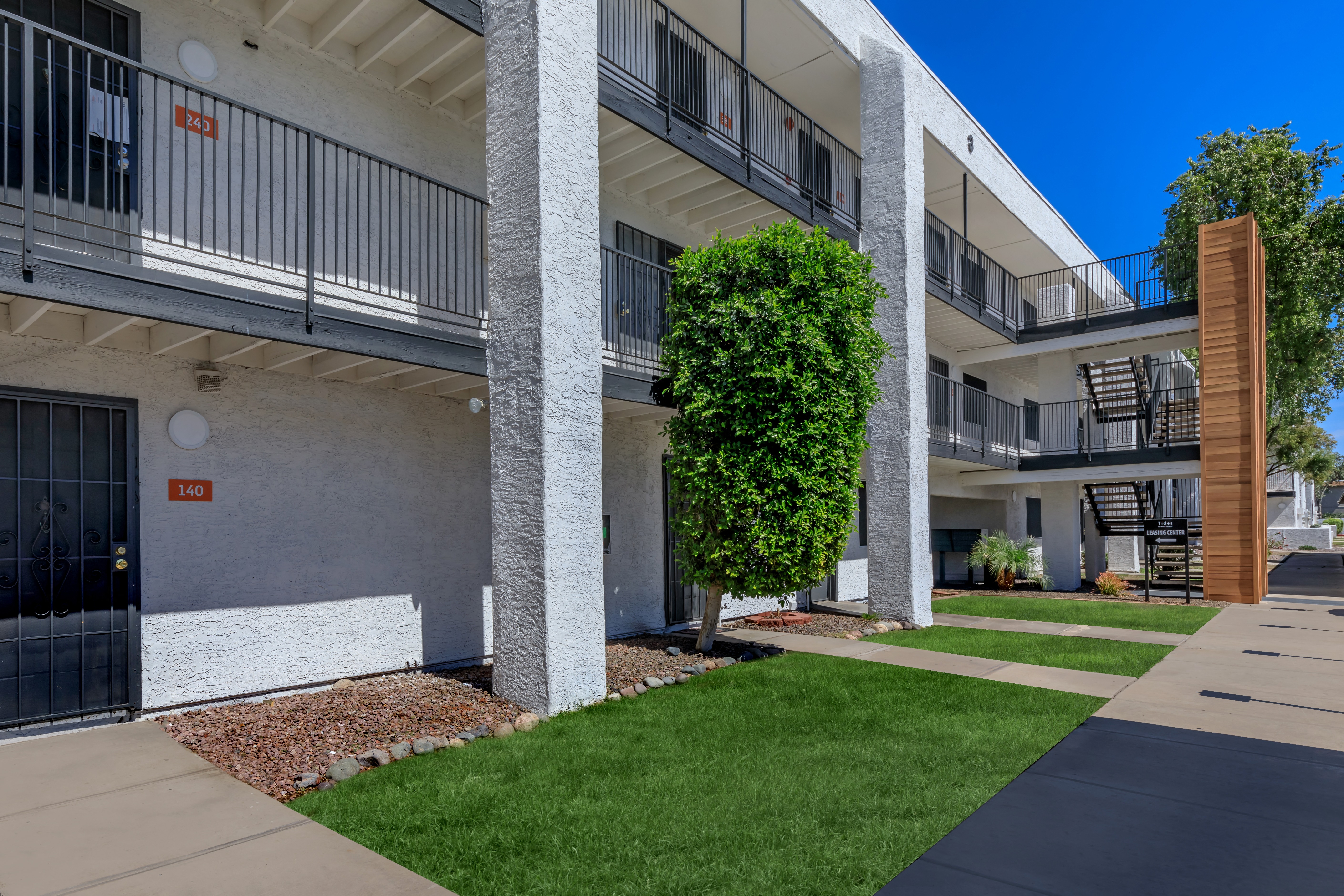 an exterior view of a building with green grass and a sidewalk