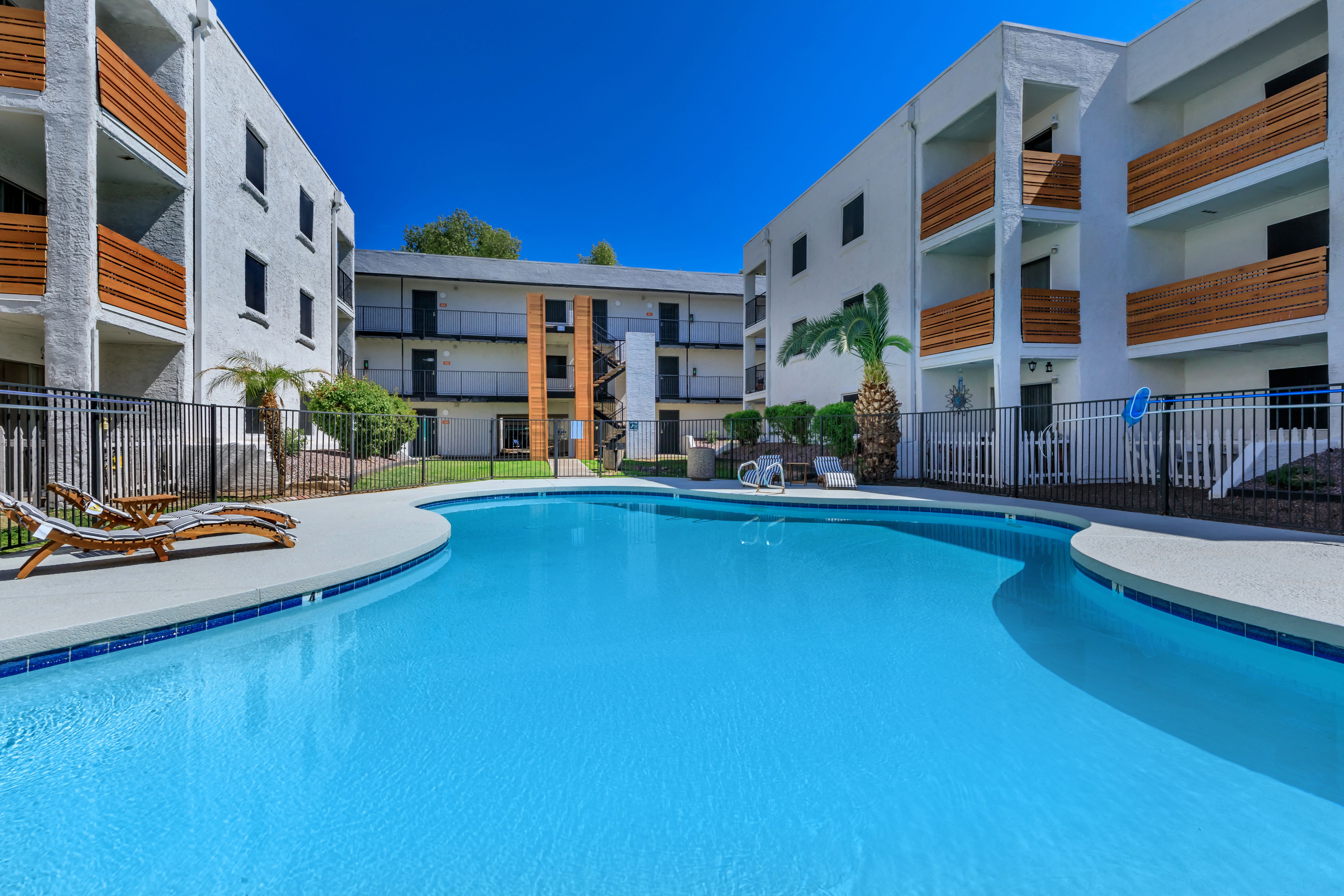 a large swimming pool in front of an apartment building