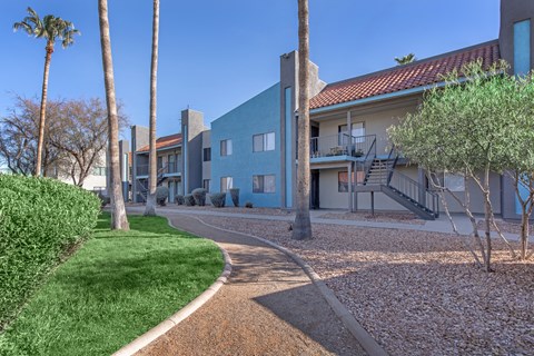 A building with a blue door and a green lawn in front.