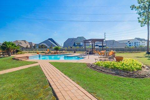A backyard with a pool and a patio area.