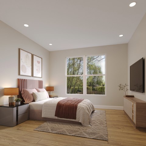 A bedroom with a large bed and a window overlooking a tree-filled yard.
