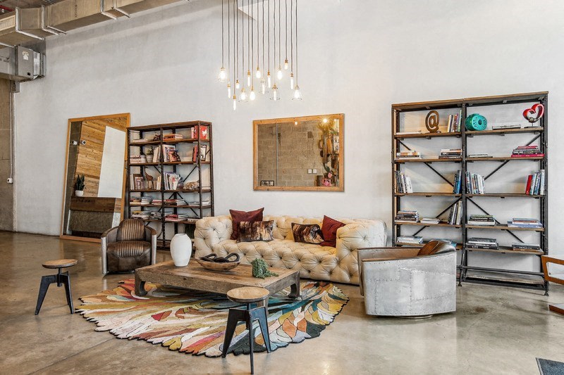 A living room with a white couch, a rug, and a bookshelf.