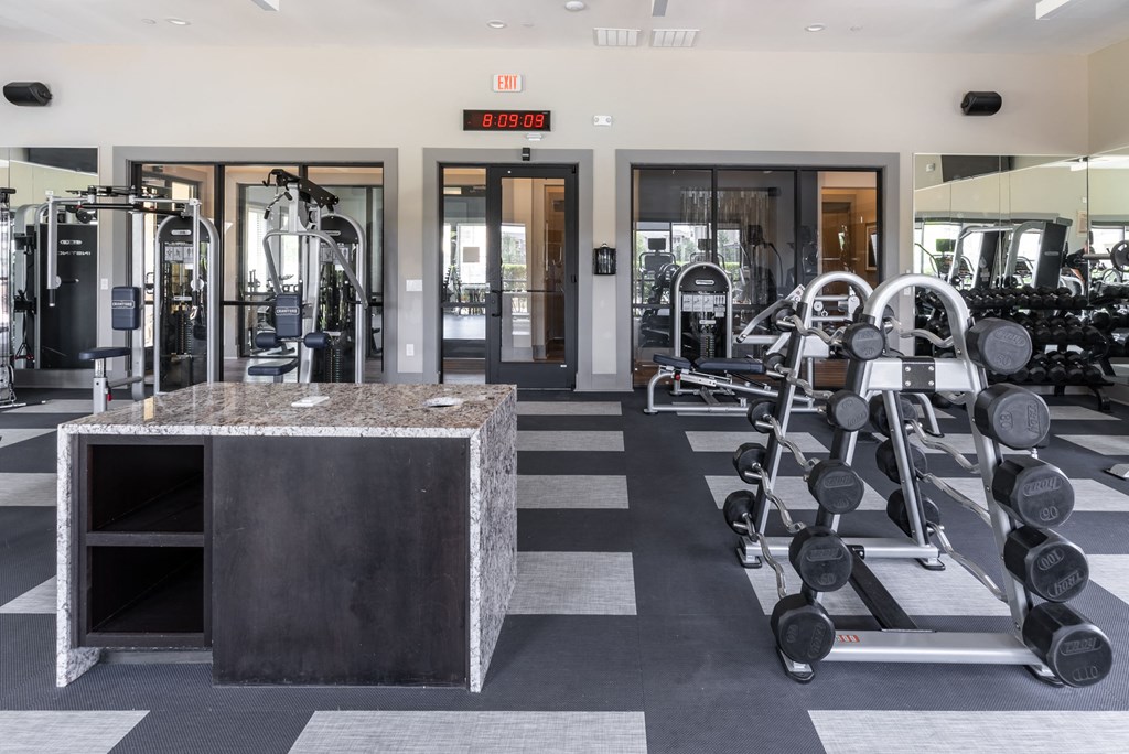 a view of the fitness center with weights machines and mirrors