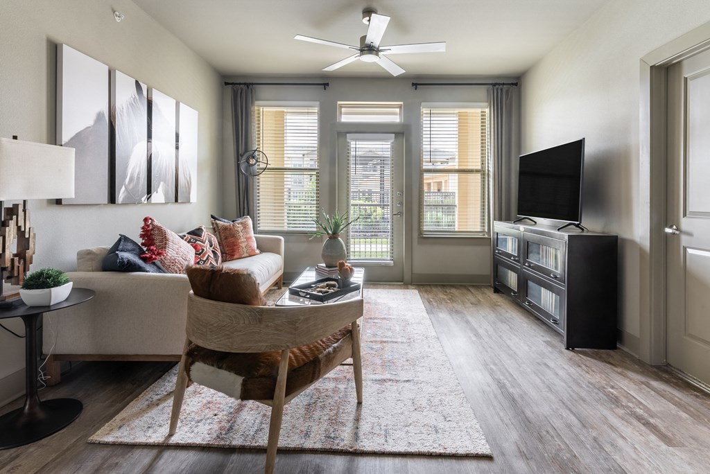 a living room with hardwood floors and a ceiling fan