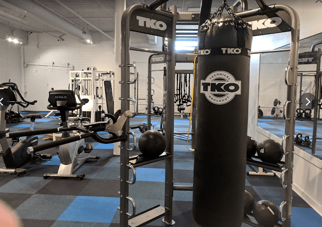 A gym with a TKO punching bag and various exercise equipment.