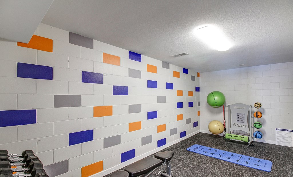 a therapy room with colorful tiles on the wall and a green ball on the floor