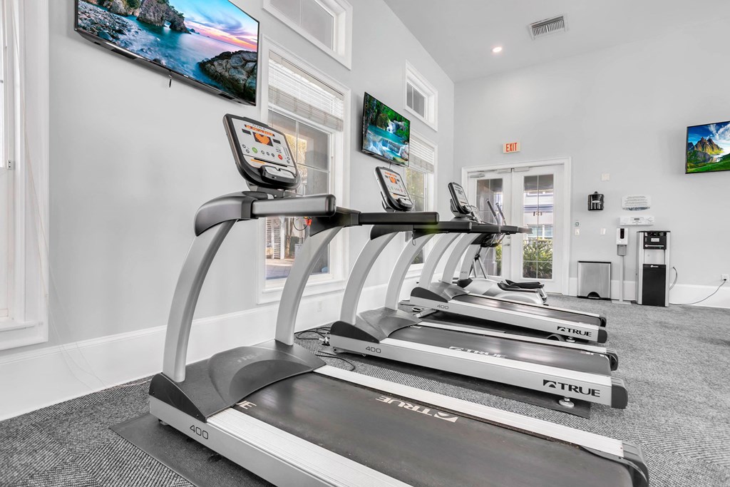 the gym is equipped with treadmills and televisions