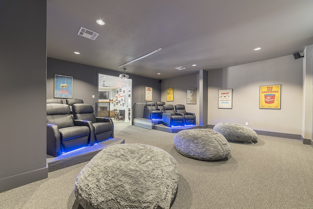 a theater room with couches and chairs and rocks in the floor