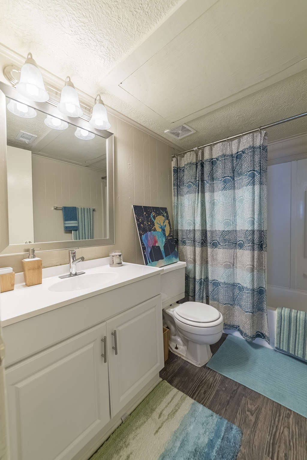 a bathroom with a white sink and toilet and a shower curtain