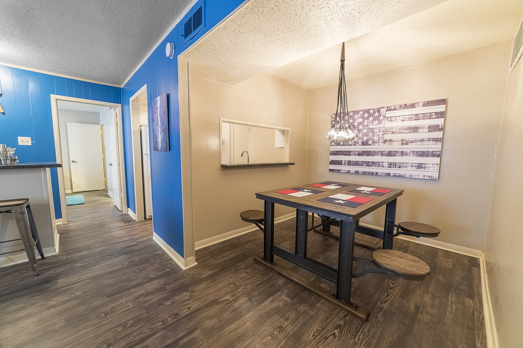 a game room with a table and chairs and a hallway with a door