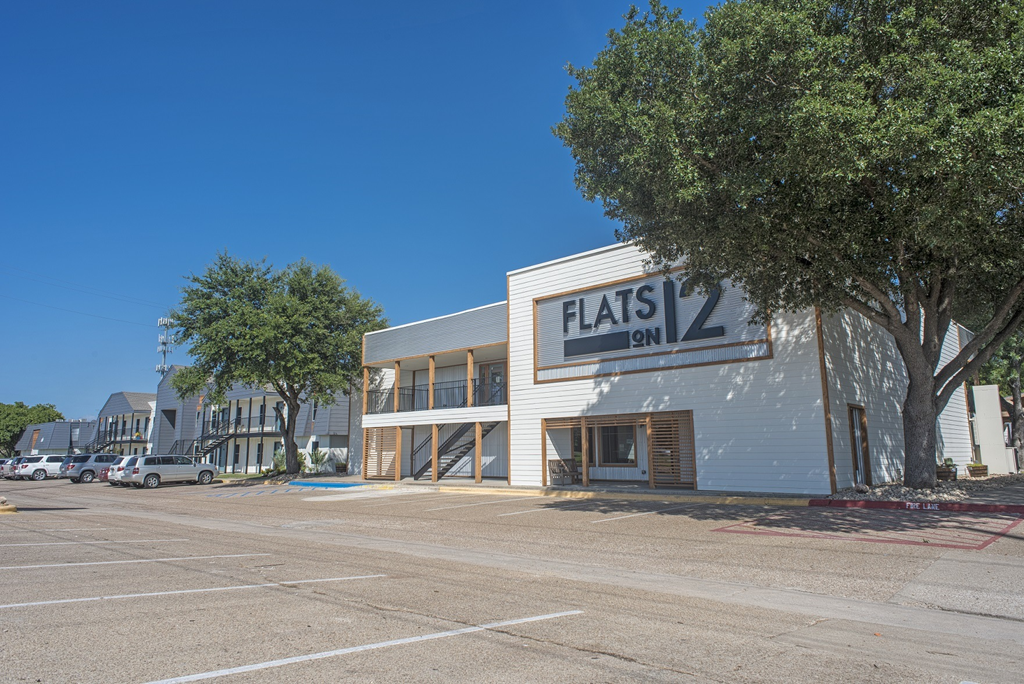 a white building with a sign that reads flash evil on it in a parking lot
