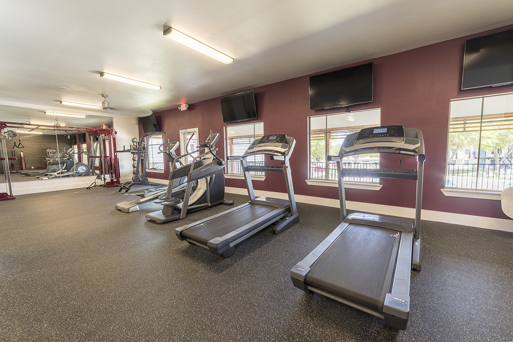 a gym with treadmills and other exercise equipment at the enclave at university crossings
