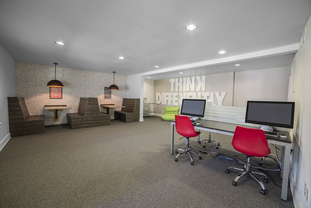 an open office space with desks and chairs and a wall with a quote on it