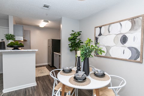 an open kitchen and dining area with a table and plants