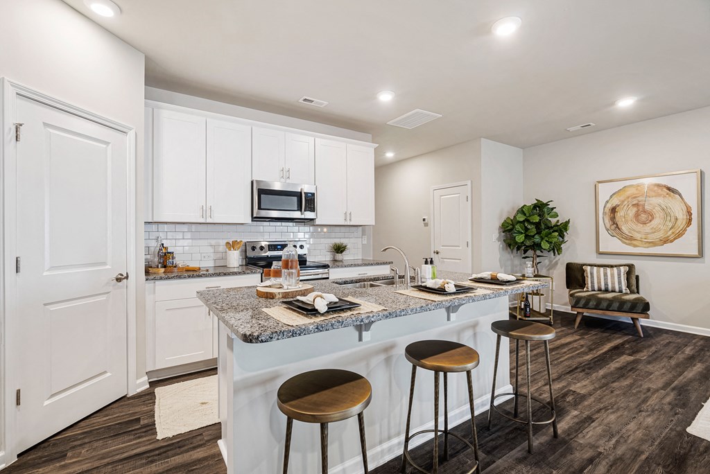 A kitchen with a bar stool and a counter.
