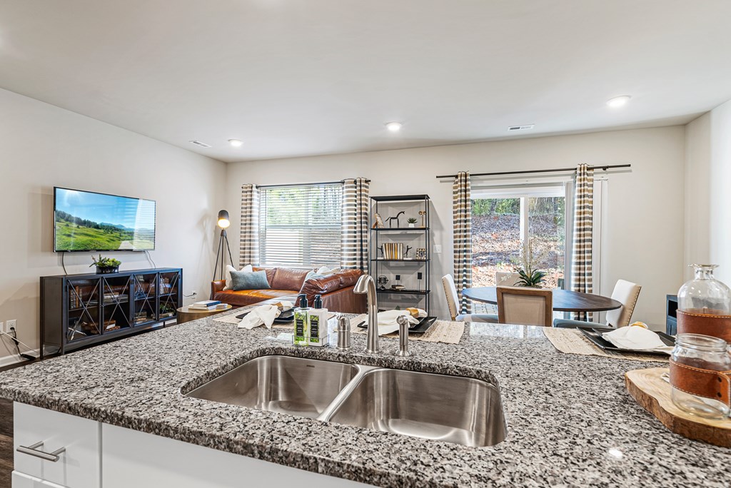 A modern kitchen with granite countertops and stainless steel appliances.