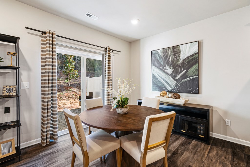 A dining room with a wooden table and chairs.