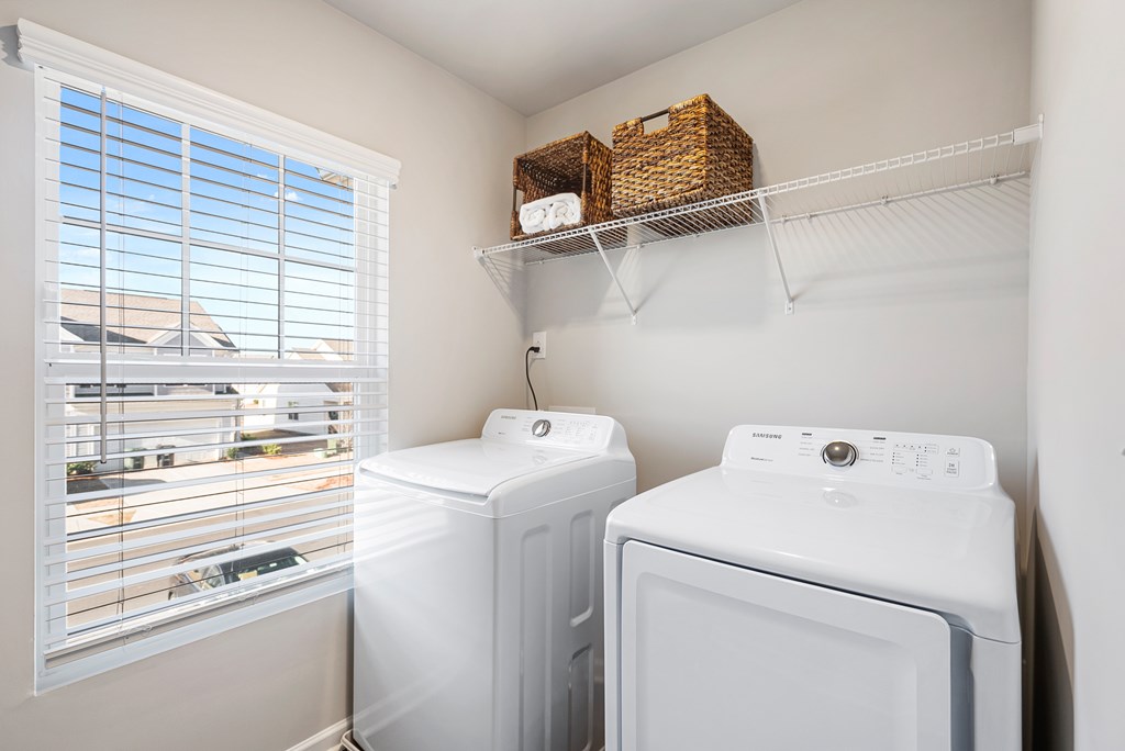 A laundry room with a window and a washer and dryer.