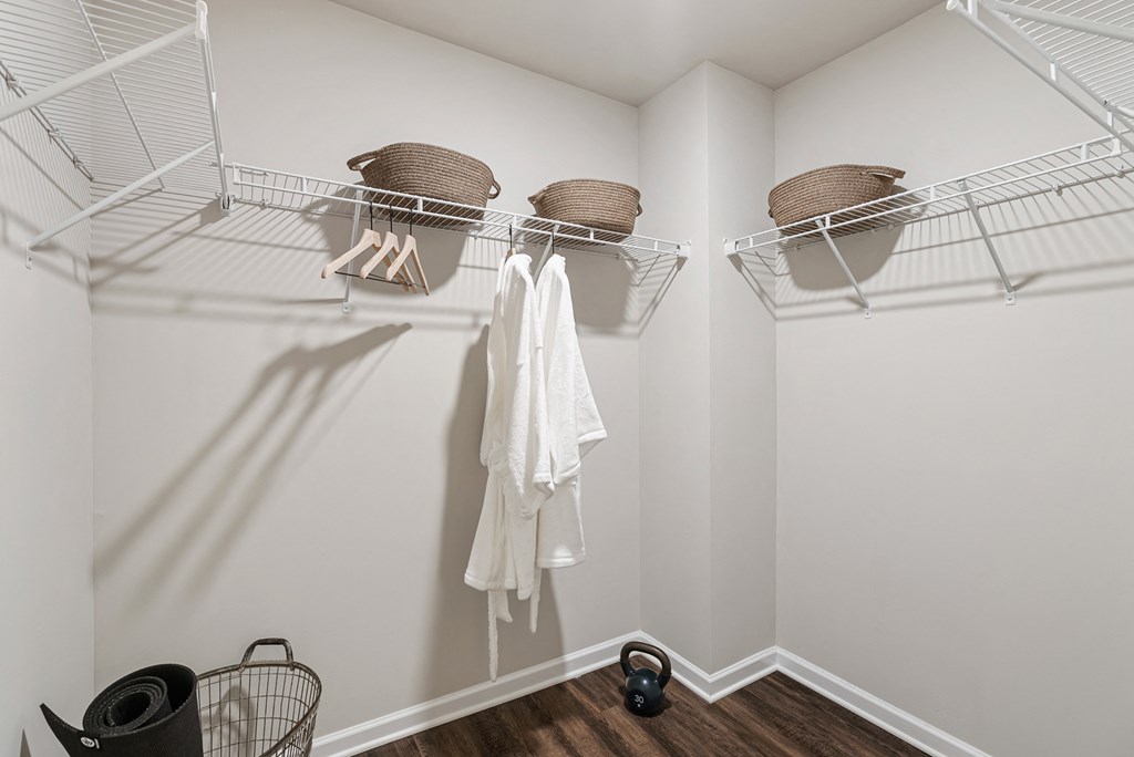 A white closet with a white towel hanging on a rod.