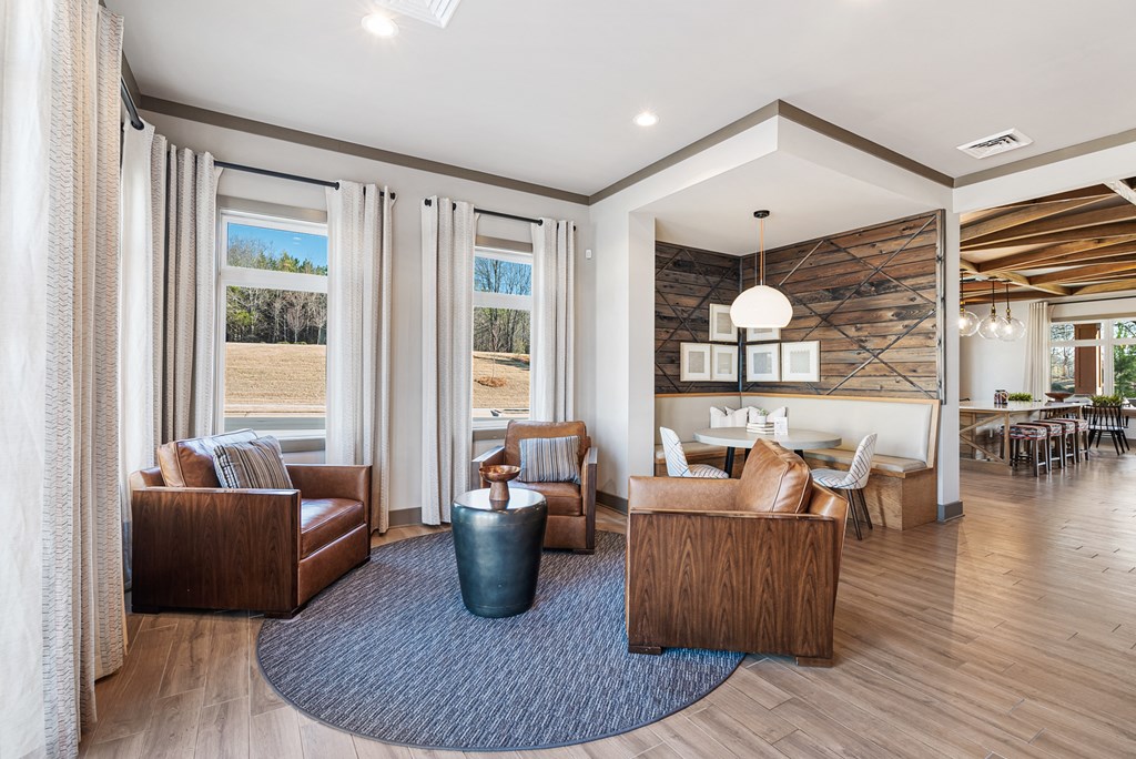 A living room with a large window and a view of trees.