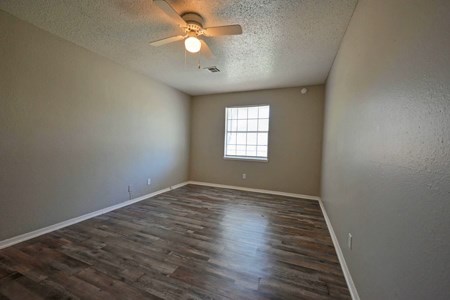 A room with a ceiling fan and a window.