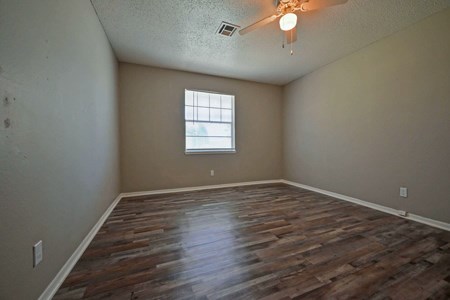 A room with wooden flooring and a window.