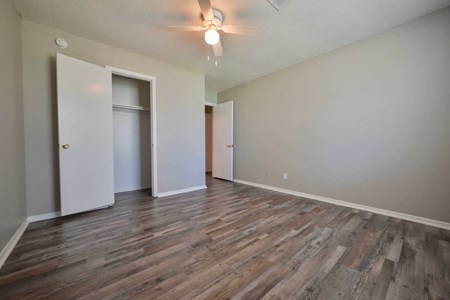 A room with wooden flooring and two doors.