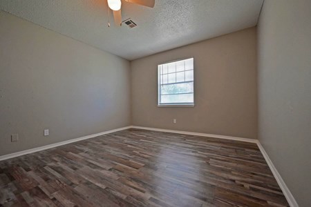 A room with wooden flooring and a window.