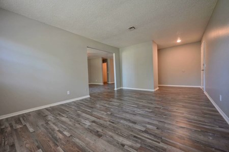 A room with wooden flooring and white walls.