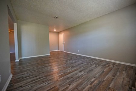 A room with wooden flooring and white walls.