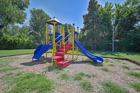 A playground with a blue slide and red steps.