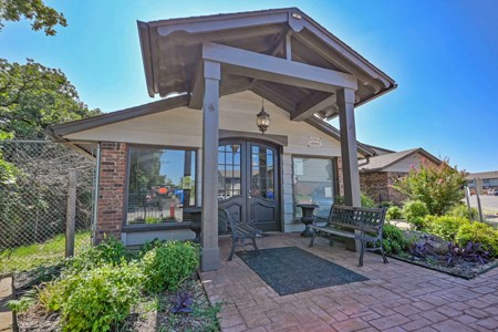 A small house with a porch and a fence.