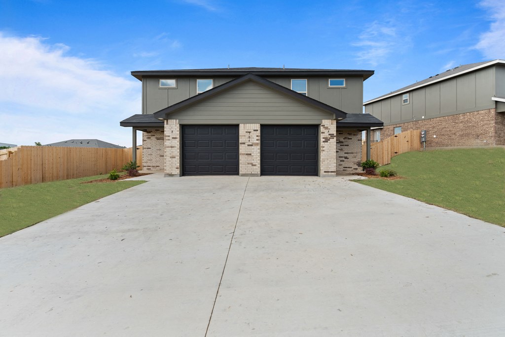 a large driveway in front of a house with a garage door